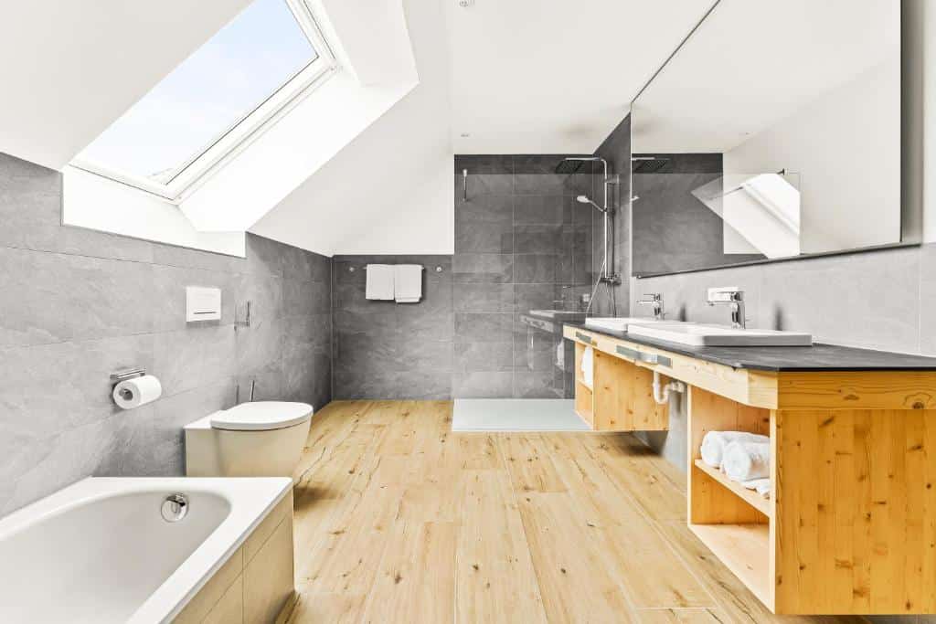 Bad mit Dusche, Badewanne, Waschbecken und Dachfenster mit Ausblick in den Schwarzwald